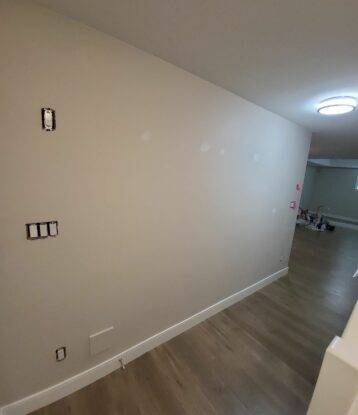 A picture of an interior wall inside a home that is being prepared for a feature wall that will involving many colours,