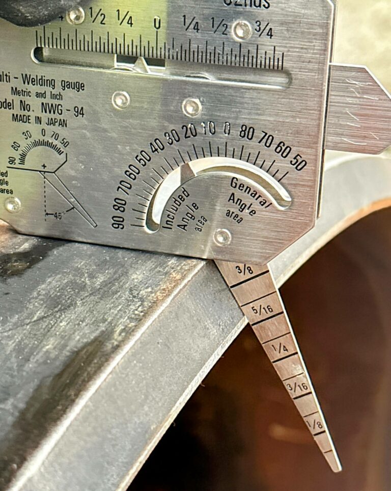 Close-up image of a welding gauge measuring weld quality and thickness. The gauge features a display and precision markings, designed for accuracy in welding applications. Ideal for professionals in metal fabrication and welding industries.